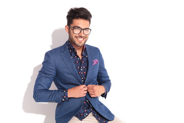 laughing young man unbuttoning his coat