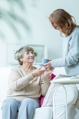 Obraz premium Serving tea to older lady