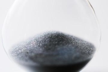 close up of hourglass with black sand