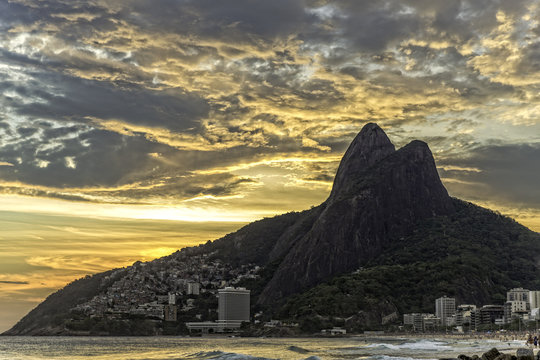 View of Ipanema Beach and Padre Dois Irmaos against dramatic sky, Rio De Janeiro, Brazil
