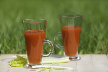 Tomato juice with celery on a wooden board