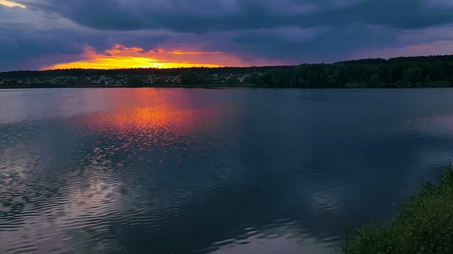 Sunset at big summer lake near the village