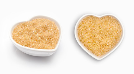 Brown sugar  in a heart shaped bowl, isolated on white