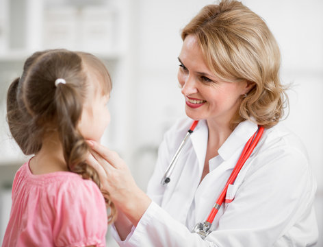 Pediatrician doctor examining kid in her office