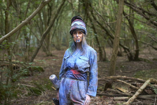 Paintball player in paintball wear marked with paint