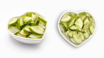 sliced cucumbers  in a heart shaped bowl, isolated on white