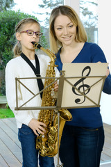 Kind bei Musikunterricht lernt Saxophon spielen 