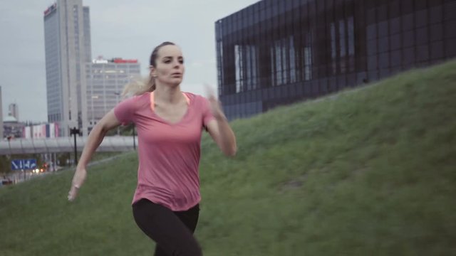 Young woman running fast in a city during evening
