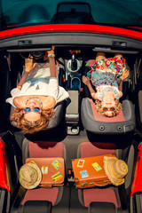 Happy family travel by car. Woman and child having fun in red cabriolet. Summer vacation and travel...