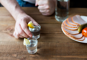 Shot glasses of vodka on a wooden table