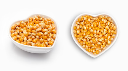 Corn seeds  in a heart shaped bowl, isolated on white