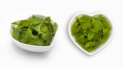 Fresh mint leaves in a heart shaped bowl, isolated on white