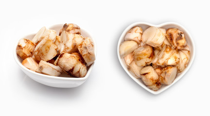 Fresh galangal  in a heart shaped bowl, isolated on white