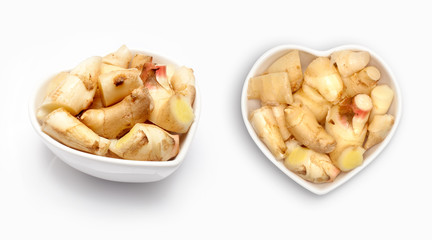 Fresh ginger  in a heart shaped bowl, isolated on white
