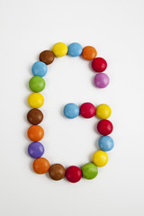 La lettera G formata da coloratissimi confetti di cioccolato.