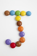 La lettera J formata da coloratissimi confetti di cioccolato.