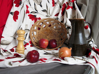 staged still life with red, grey and white color drapery, apples