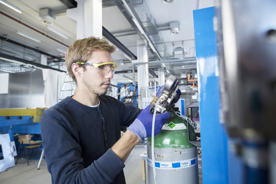 Factory technician checking valves in factory