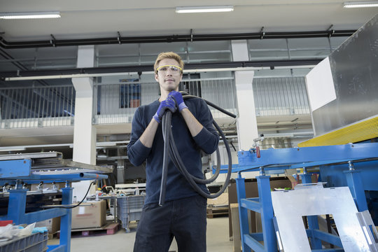 Portrait of factory technician with roll of cable