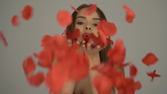 beauty brunette woman blowing rose petals slow motion video 