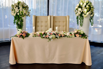 Beautiful wedding restaurant for marriage. White decor for bride and groom. Colorful decoration for celebration. Beauty bridal interior. Bouquet, food and flowers in hall