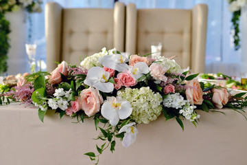 Beautiful wedding restaurant for marriage. White decor for bride and groom. Colorful decoration for celebration. Beauty bridal interior. Bouquet, food and flowers in hall