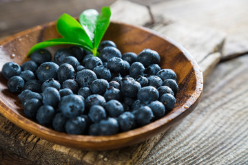 Fresh blueberries in a wooden plate
