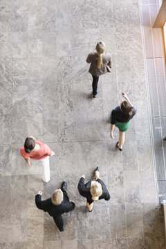 Overhead view of businesswomen and man walking in same direction