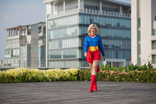 Attractive confident superwoman walking outdoors: female power