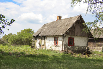 Obraz premium Old abandoned farmhouse near blooming trees against the bright spring sky - life goes on. «If time exists in nature, then it is not already open ...». (Konstantin Tsiolkovsky).