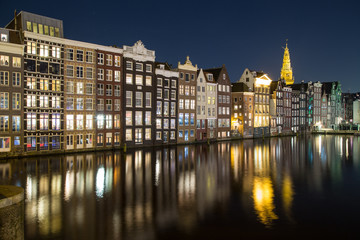 Fototapeta na wymiar Buildings along the Damrak at Night in Amsterdam
