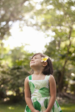 Young girl in garden, wearing flower in her hair