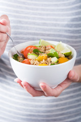 Woman eating quinoa and vegetables
