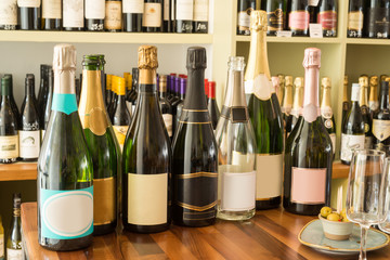 Empty and Unopened Wine Bottles By Wineglasses and Olives