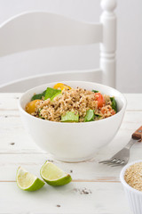 Quinoa salad in bowl with tomatoes and spinach
