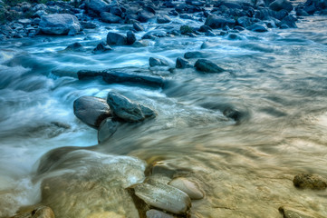 River water flowing through rocks at dawn