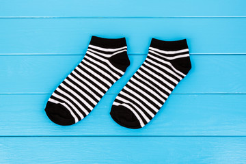 Pair of socks laying on a blue wooden background.