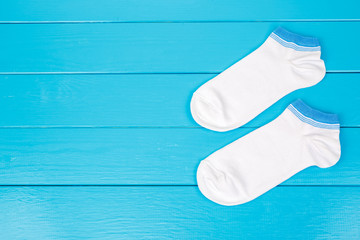 Pair of socks laying on a blue wooden background.