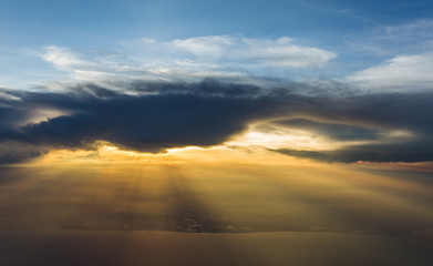 Fototapeta na wymiar light beam of sunlight through clouds above sunset sky