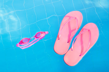 Googles and flip-flops in swimming pool. Vacation. Resort. Background