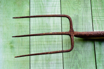 Rusty pitchfork on wooden planks