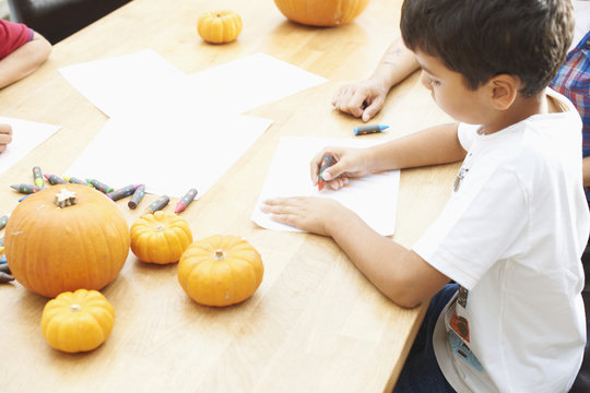 Siblings drawing at dining table