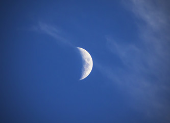 waxing moon on a background of blue sky and clouds