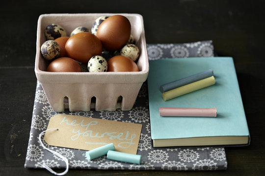Quail and chicken eggs, chalk, notebook, kitchen towel