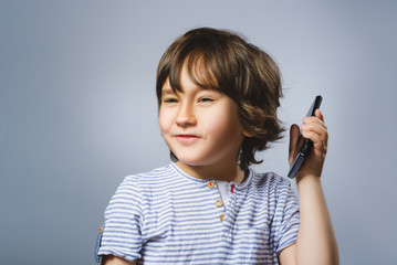Closeup Portrait of happy boy with mobile going surprise on gray background