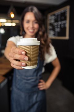 Smiling Barista Holding Disposable Cup