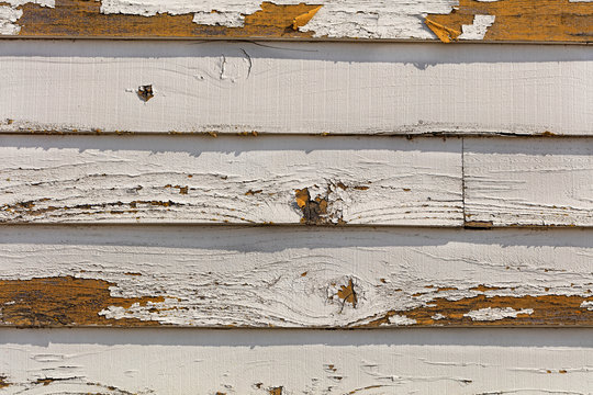 Old and fading paint peeling off of wood sliding