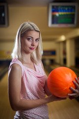 young lady at the bowling alley with the ball in hand, getting r