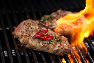 pork steak on bbq grill with flame