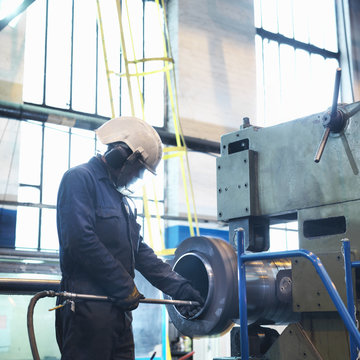 Worker polishing inside of tube in engineering factory
